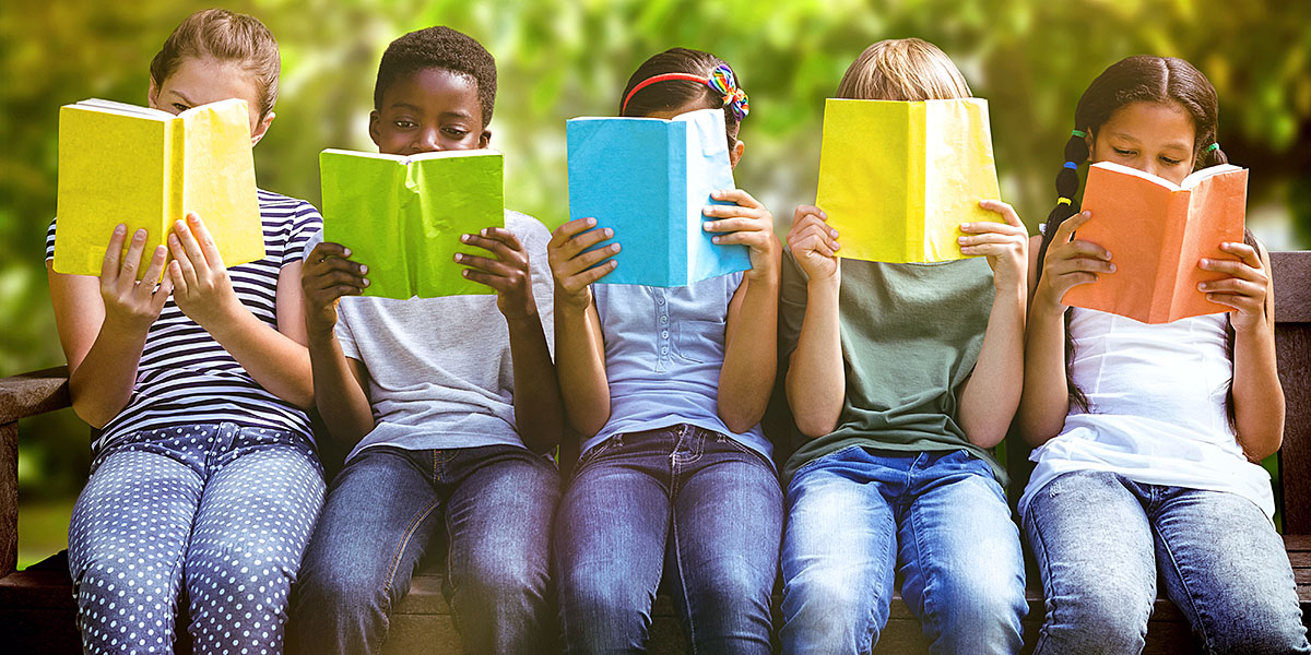 fem barn sittande på rad och läser i färgglada böcker